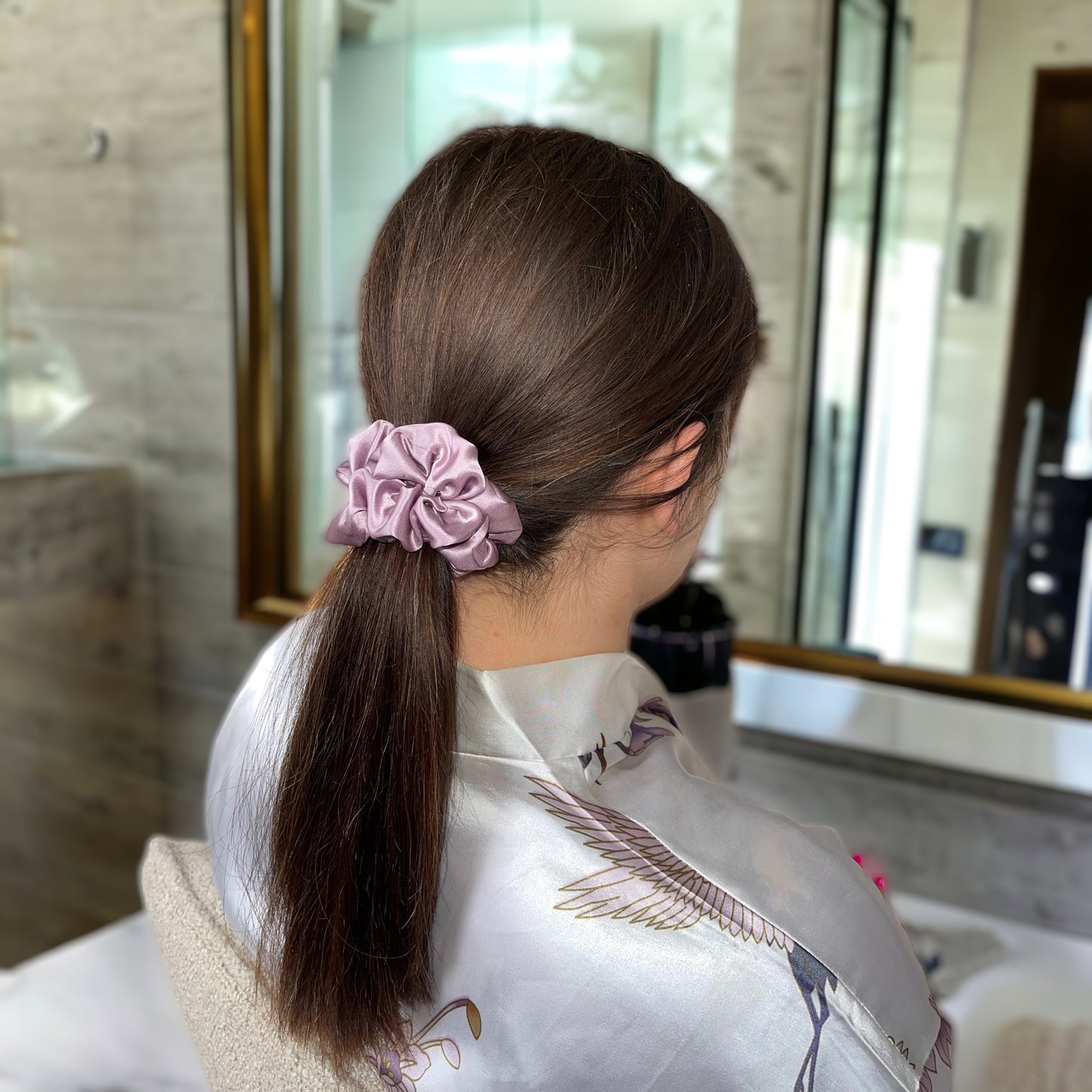 model with a ponytail hair style wearing dimo silk scrunchie in pink
