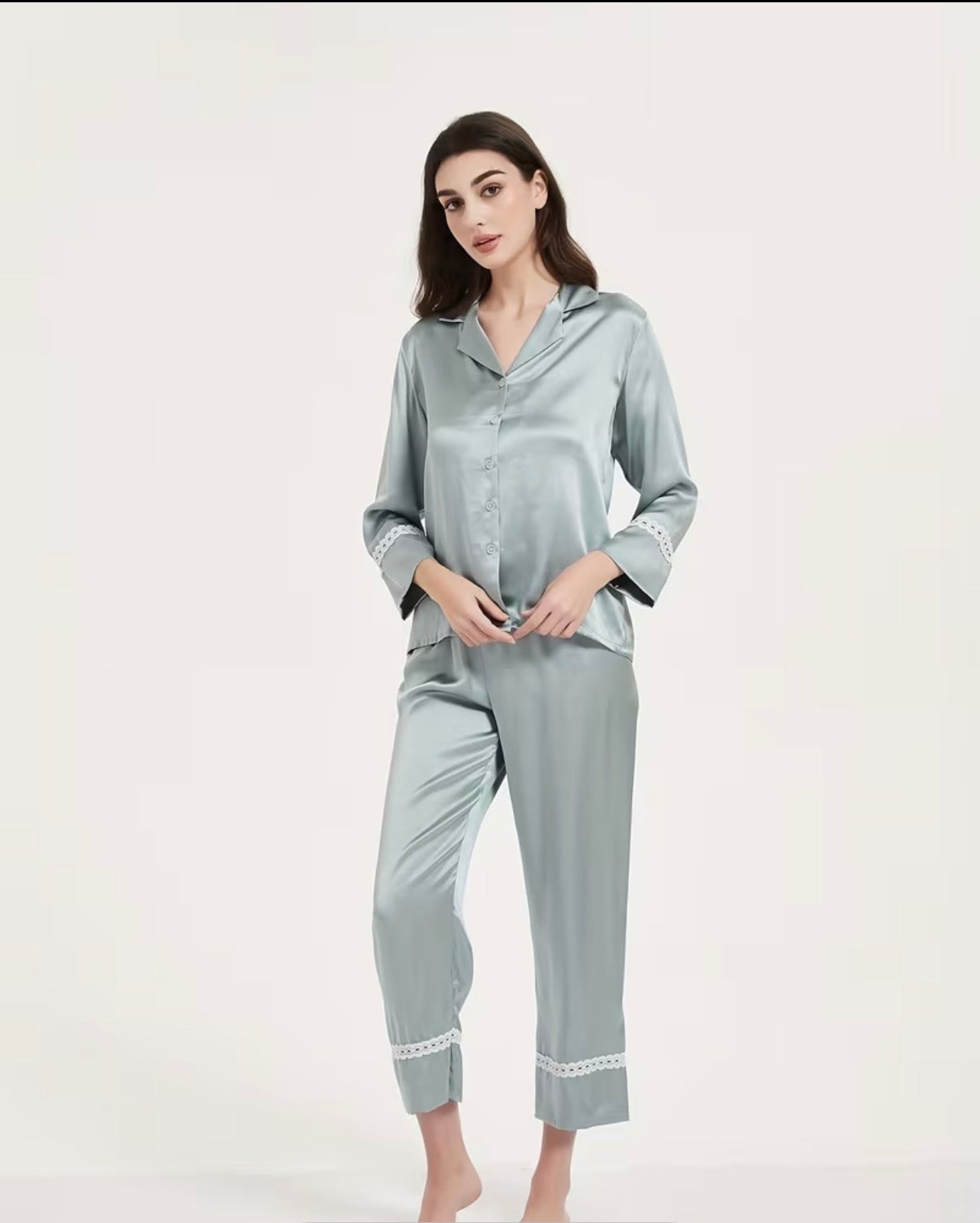 Woman wearing a light blue silk pajama set on a white background