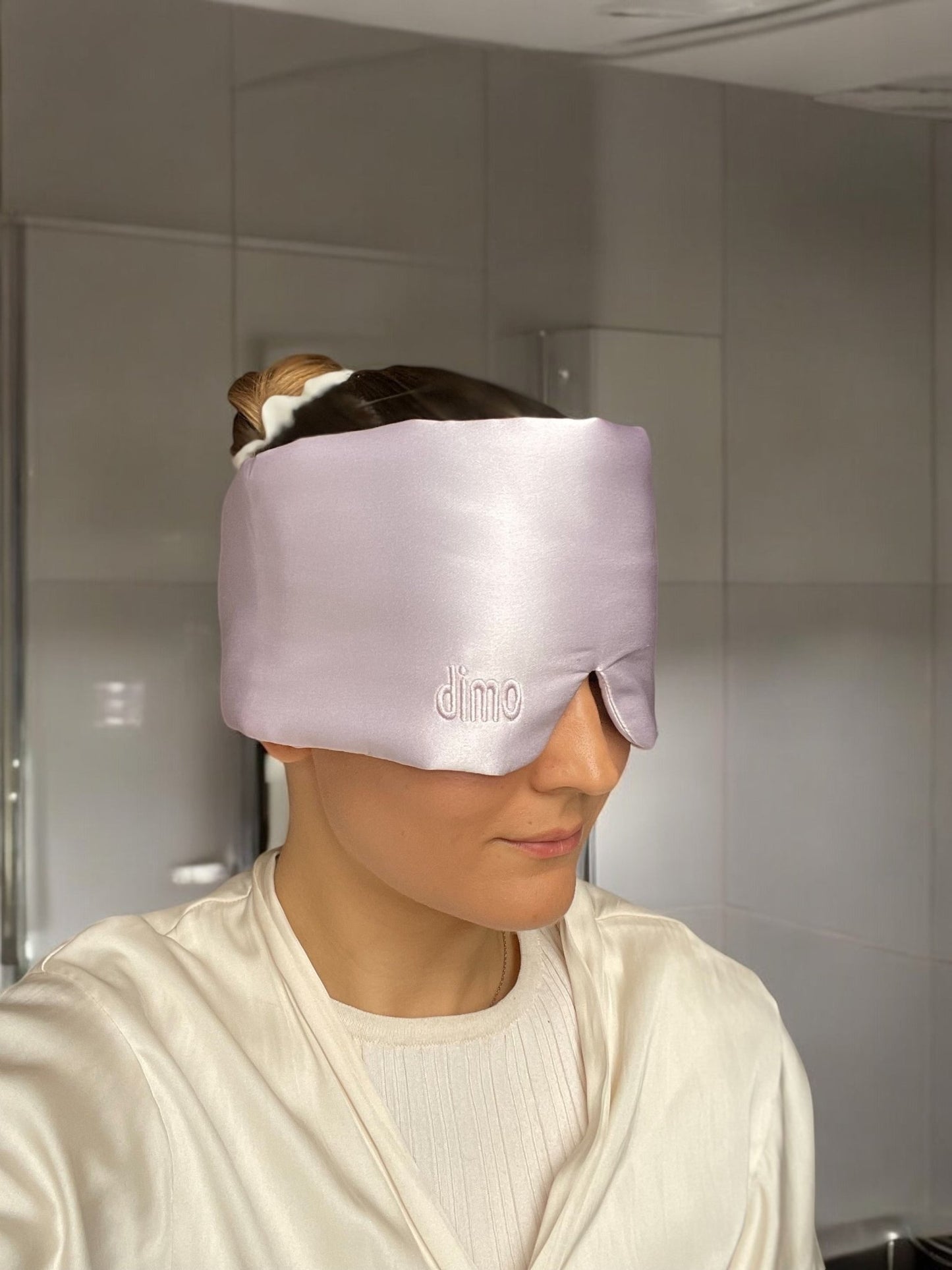 model wearing squishy silk blackout sleep mask in lavender by dimo