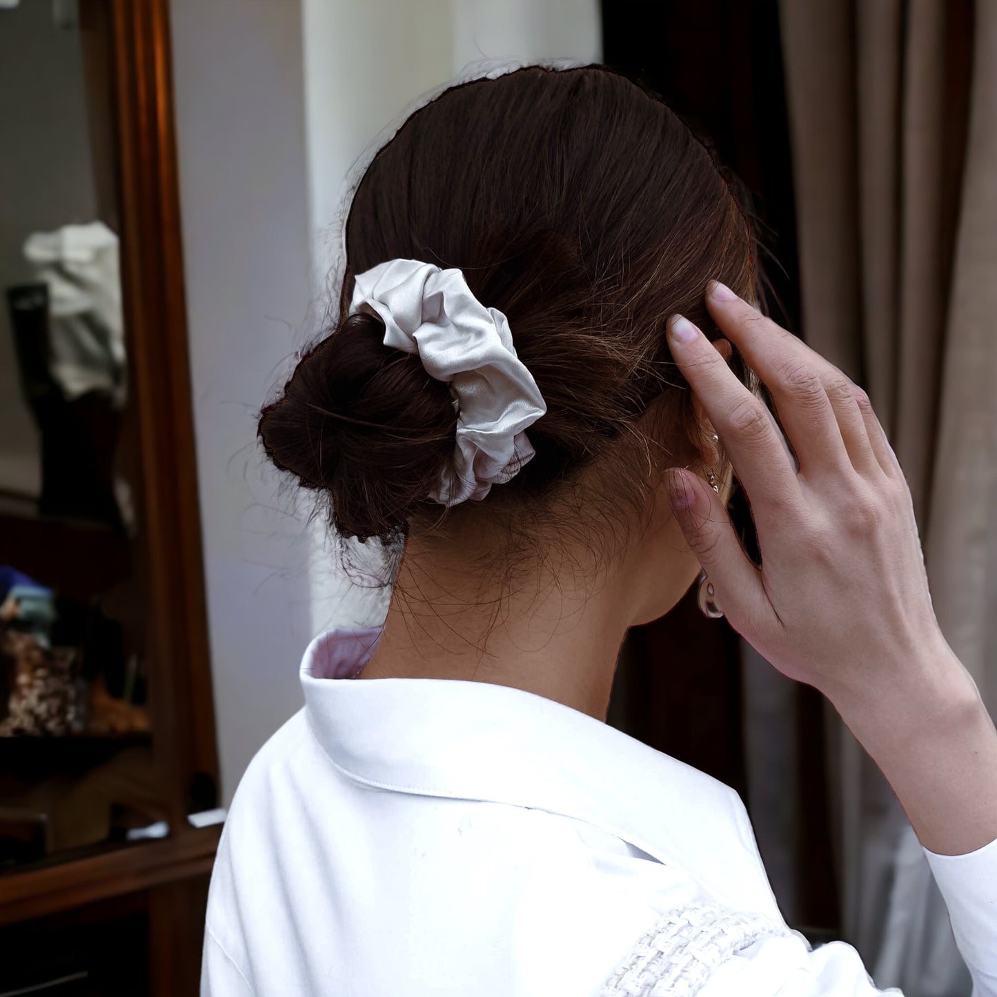 model wearing elegant silk scrunchie, perfect for all hair types, providing a gentle, damage-free hold while minimizing frizz and enhancing your hairstyle.